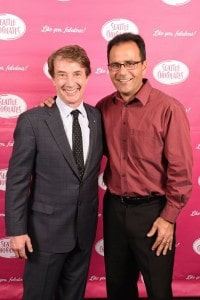 Martin Short and Michael Abella posing in front of a step and repeat background