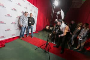two men on a red carpet being photographed